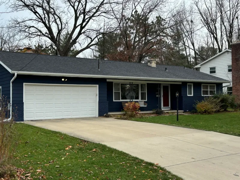 Roofing and siding work on blue house